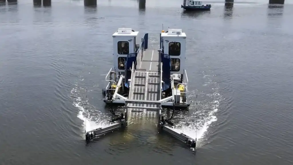 a boat collects trash via a conveyer belt loop in the water