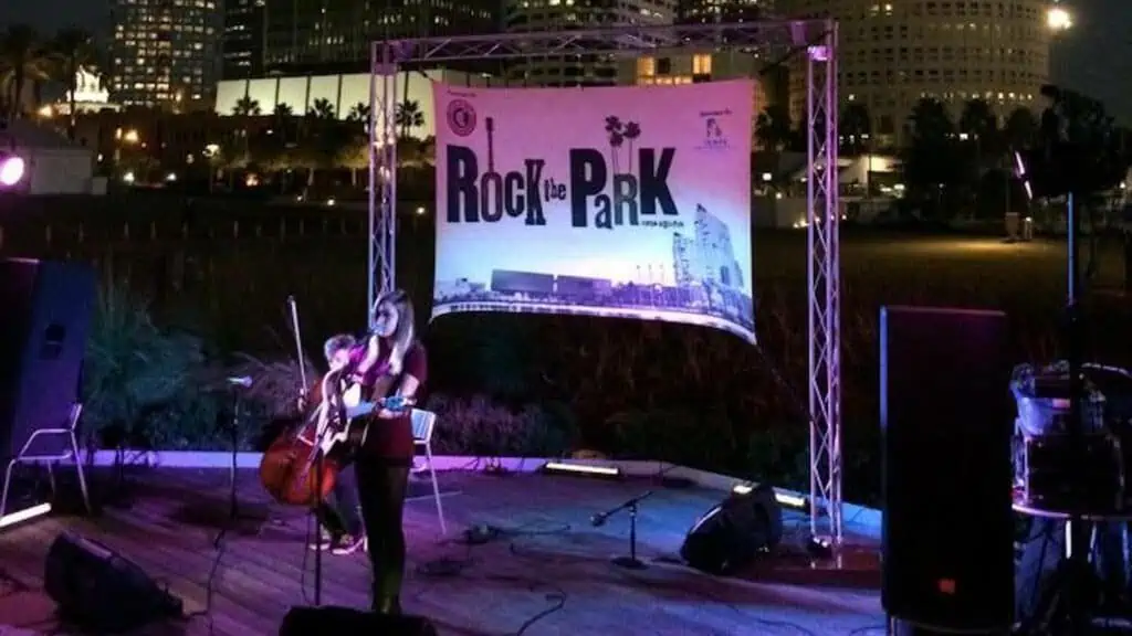 a stage set up in a park with skyline lit up in the background
