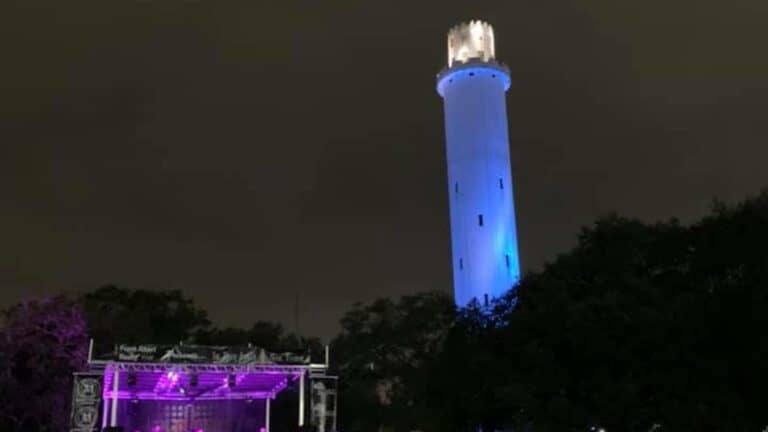 a water tower lit up in blue during an event