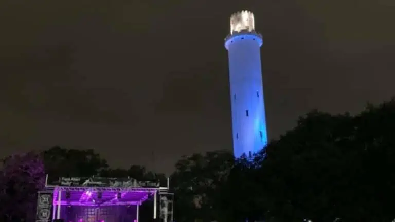 a water tower lit up in blue during an event