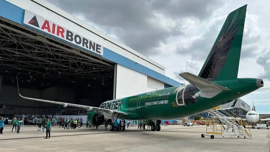 a large plane in a hangar with a green paint job