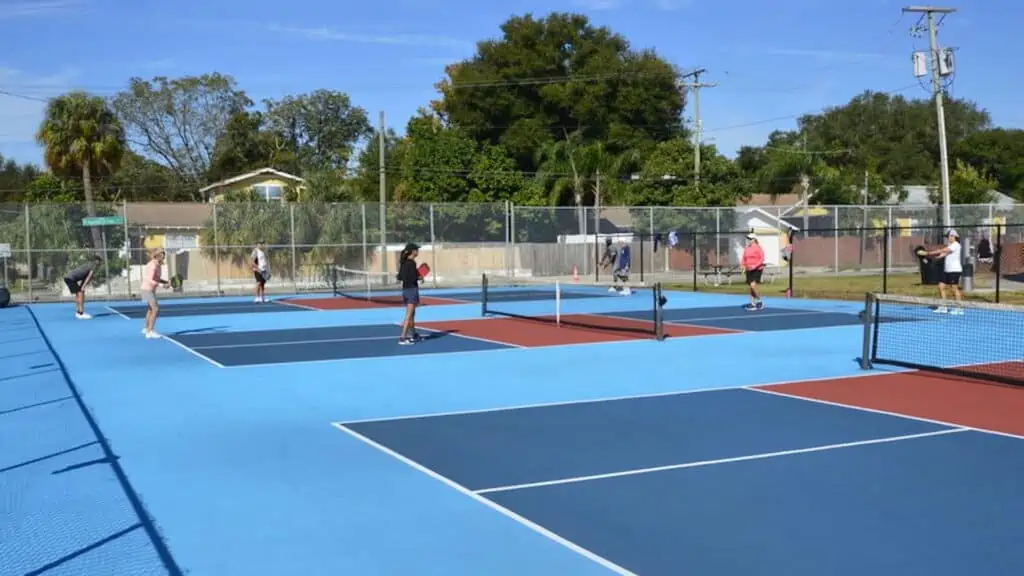 blue courts with nets. Pickleball courts with blue, pink, and dark blue paint.