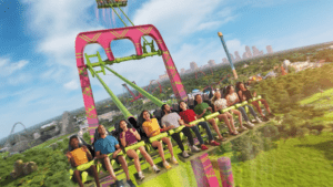 A giant swing with purple seats and light green arms soars in the air.