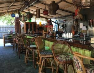 Outdoor tiki bar with tropical decorations over the bar area.
