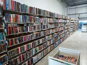 Multiple shelves of used book inside a massive warehouse.