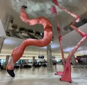 a large flamingo sculpture at the center of an airport.