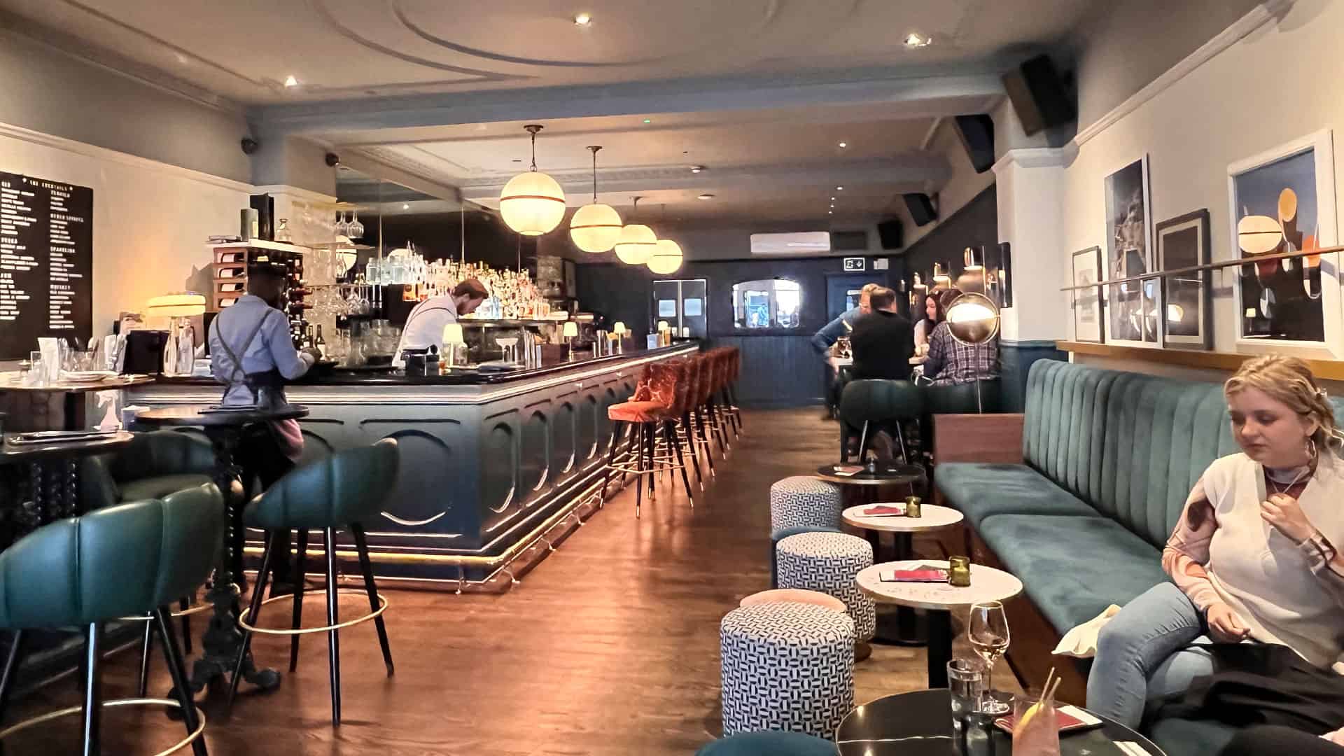 View of the bar and seating area with bartender behind the bar at Lockes Bar in Covent Garden, London