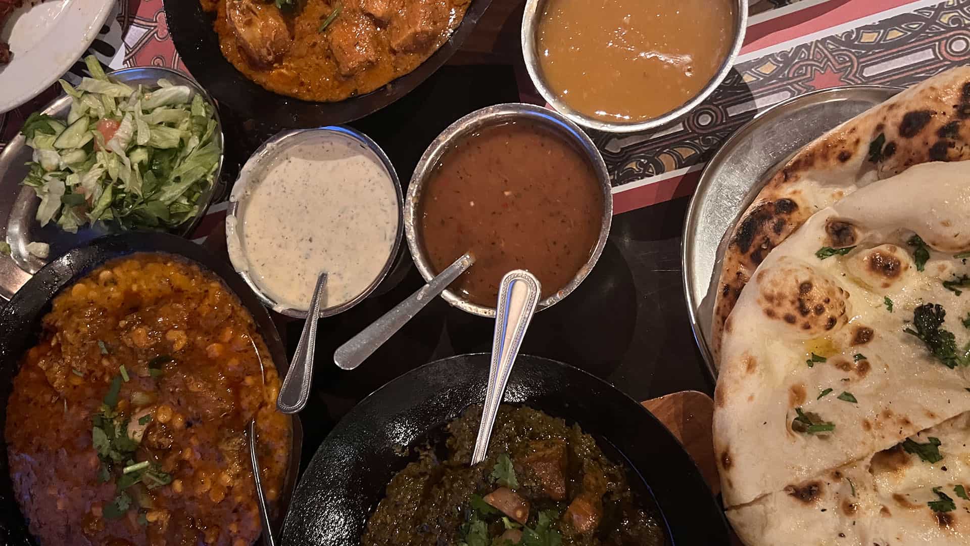 Indian, specifically Punjabi, dishes, dips and bread on the table at Tayyabs in London