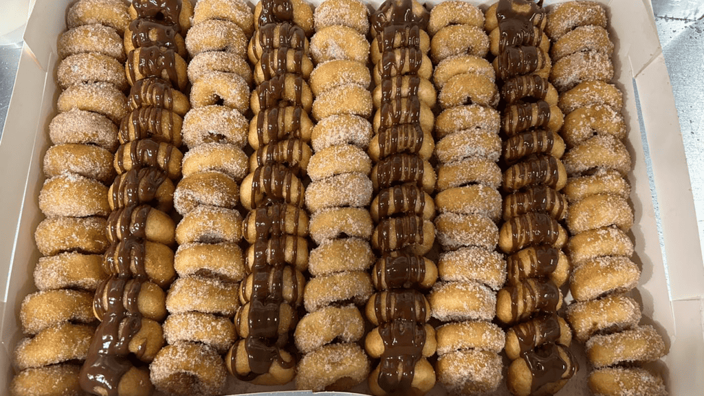 Box of mini donuts covered in chocolate and cinnamon sugar