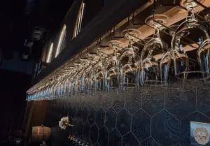 Wine glasses hung upside down from behind a bar.