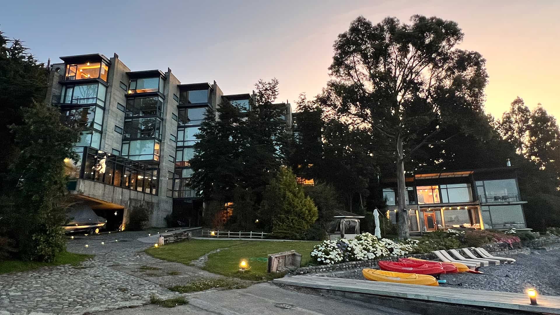 View of AWA hotel at dusk from outside showing windows and landscape