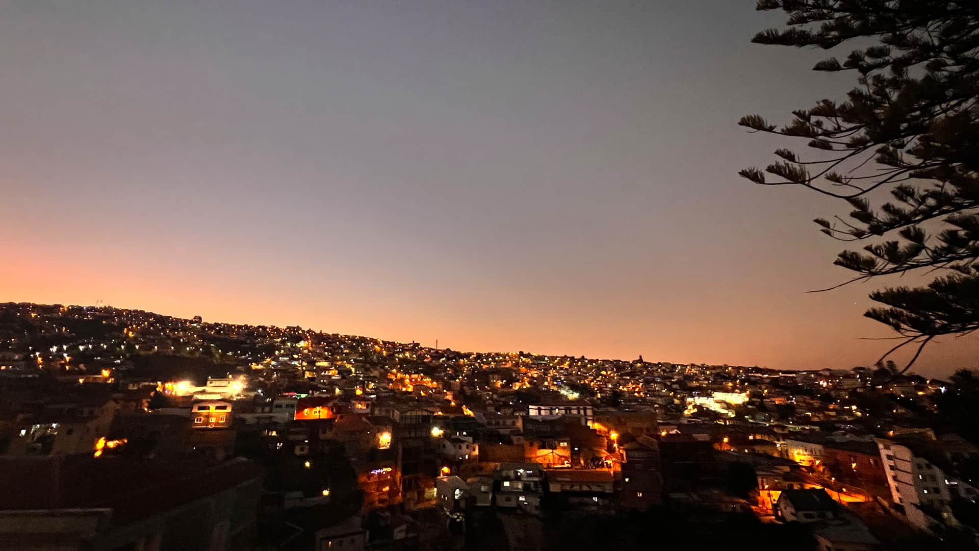 Nightime view of Valparaiso with homes lit up from the hotel roof