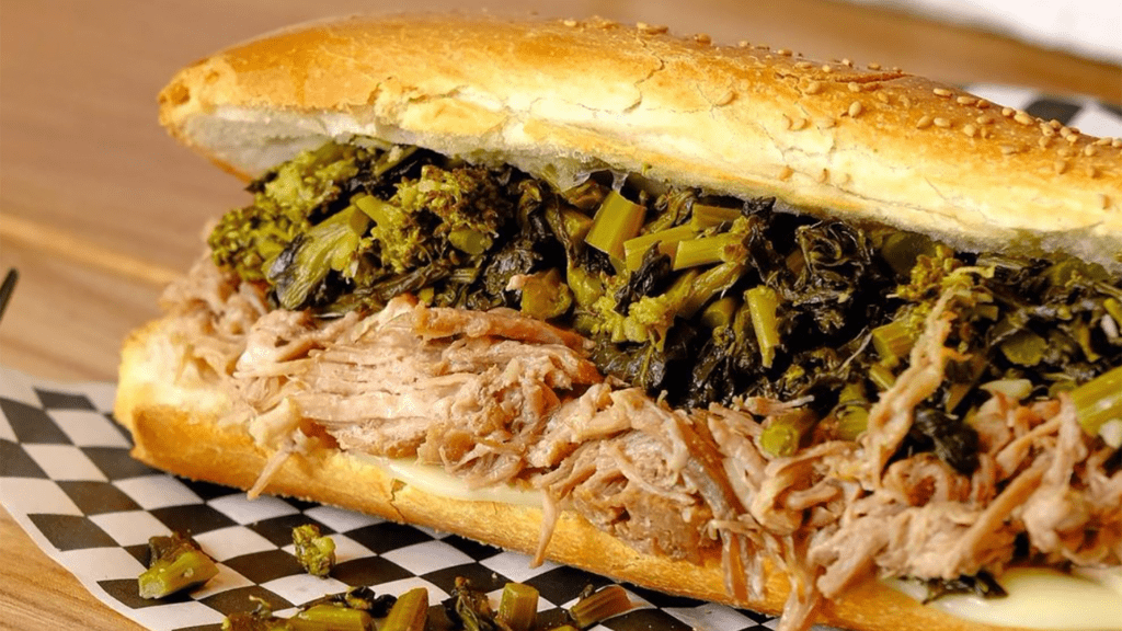 A large sub sandwich filled with shredded turkey, and green veggies. 