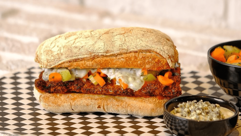 A sub sandwich filled with a chicken cutlet topped in buffalo sauce. 