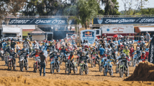 a group of riders on dirt bikes line up at the start of a track