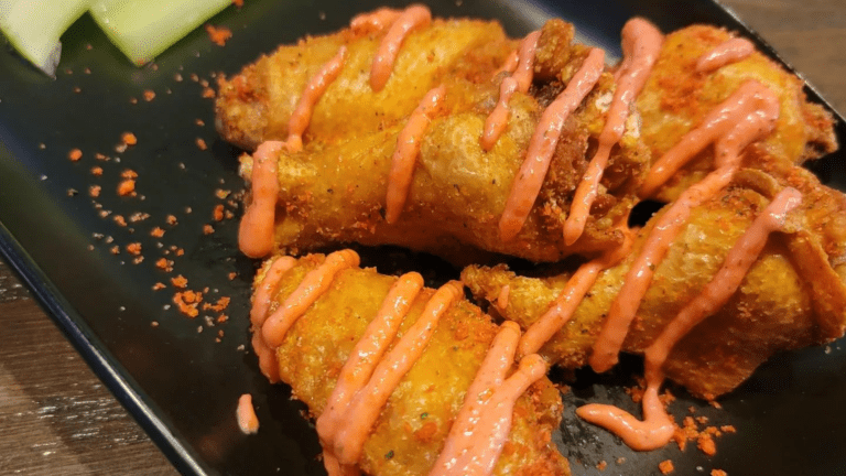 Plate of wings covered in a bright orange sauce