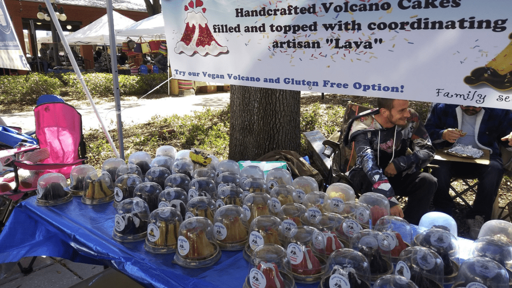 Array of lava cakes assorted on a table. A big banner that reads lava cake is set behind the table. 