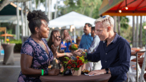 Two people at a table enjoying drinks during a big food festival