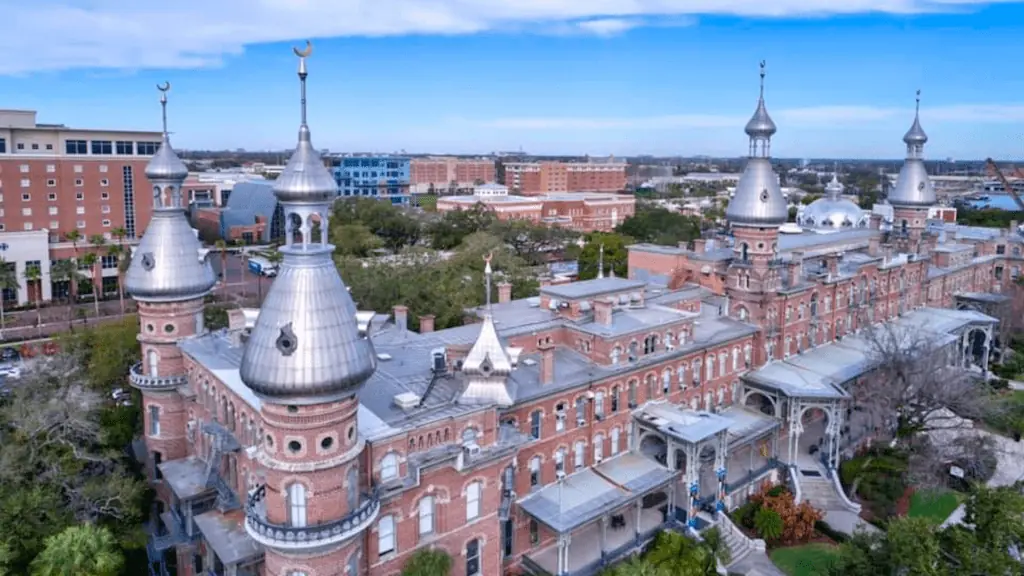 Aerial footage of historic brick building with large silver minaret structures on top.