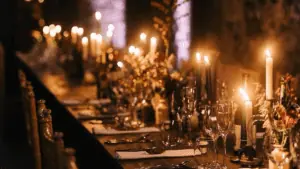 A dinner table set with multiple candles and fancy plates