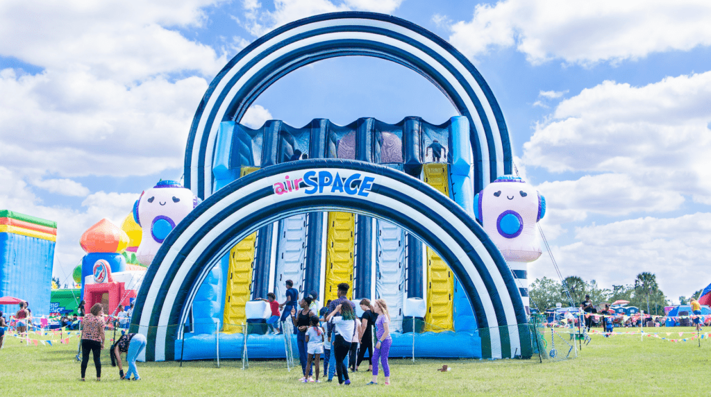 A large inflatable slide structure with two different hoops over the rows of slides. 