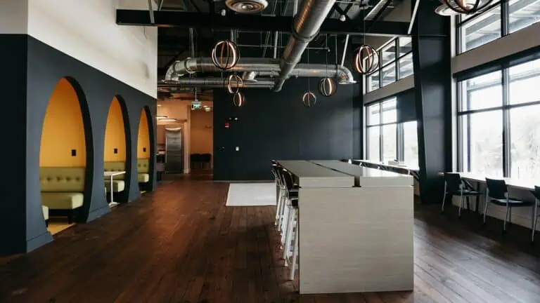 Inside a cowork space with oval meeting spaces, and a long white communal table down the center