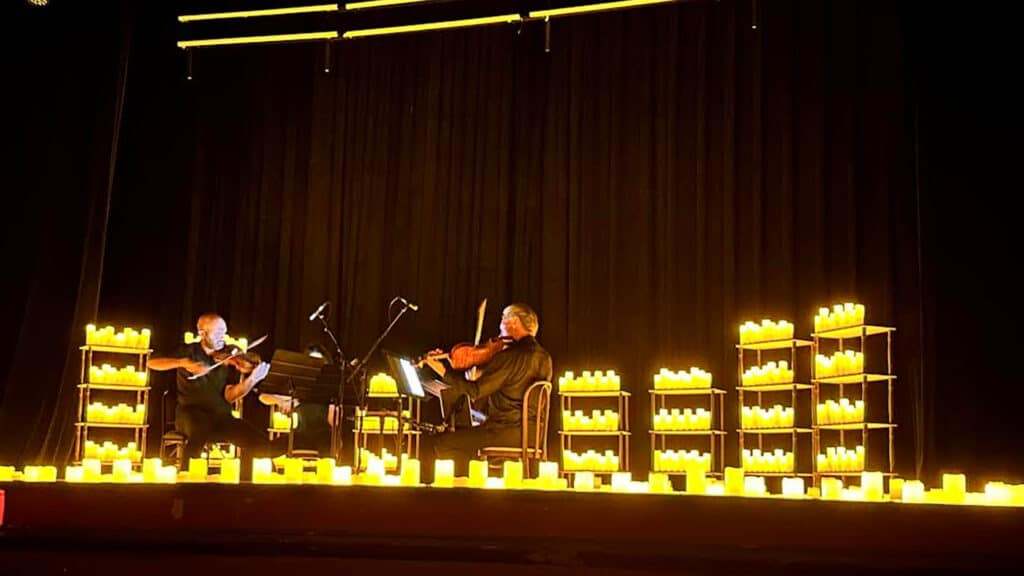 String quartet on a stage surrounded by candlelight