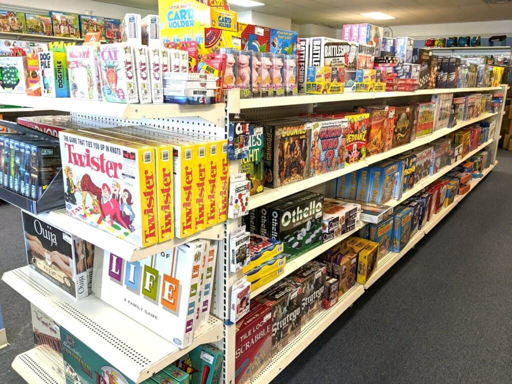 Tons of classic board games arranged in boxes on a shelf. 