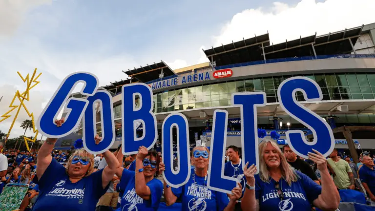 people holding a sign that says go bolts outside Amalie arena