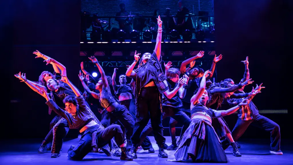 performers dancing under purple lights on stage