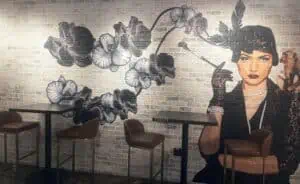 mural of a woman smoking a cigarette as flowers surround her in the background
