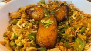 a plate of fried rice topped with plantains