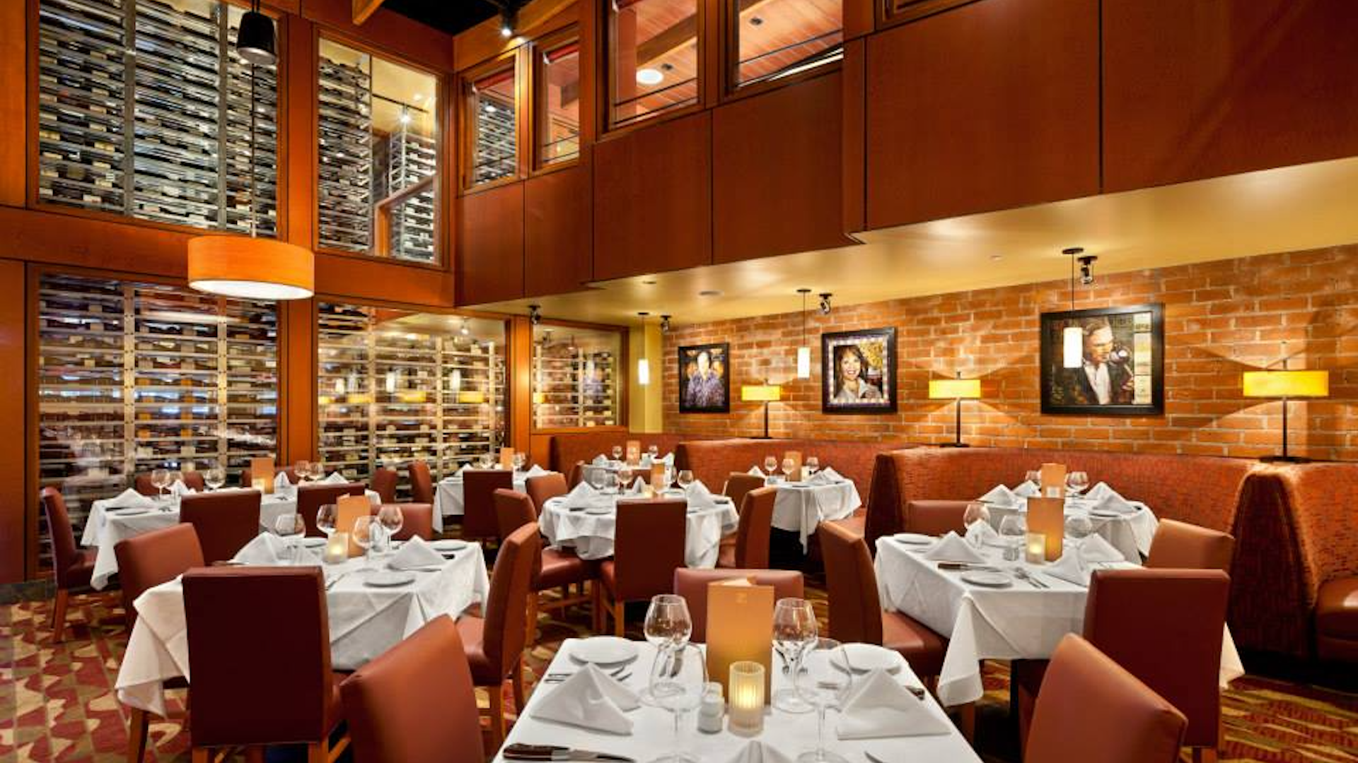 interior or a steak restaurant with tables with white linen covers.