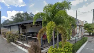 exterior of a bar with a palm tree in the front corner