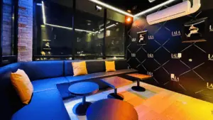 a karaoke room with orange lights and blue lights on the ceiling.