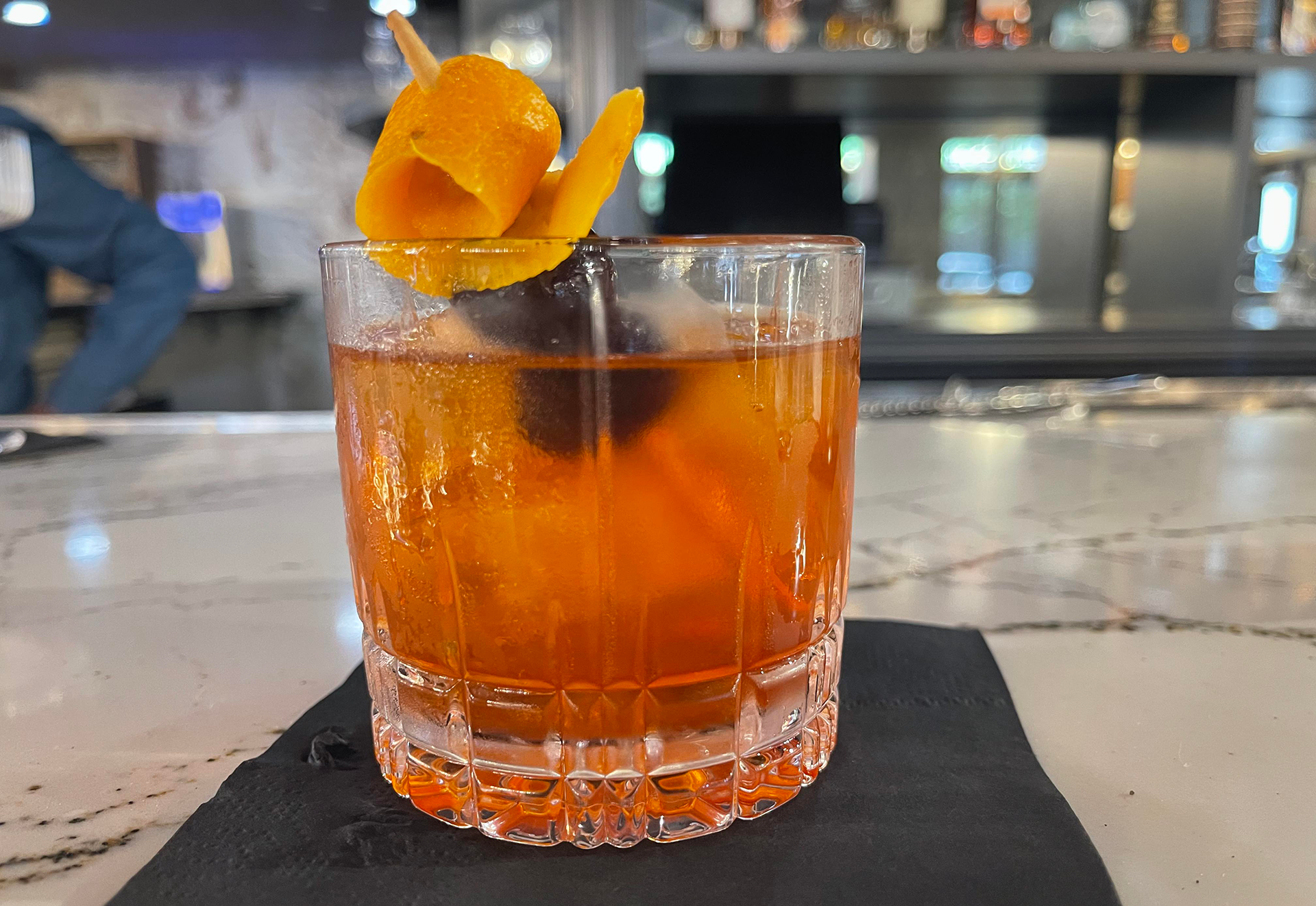 a cocktail with an orange peel swirled inside
