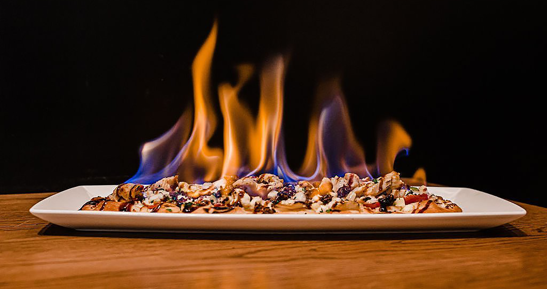 a flatbread set on fire on a plate