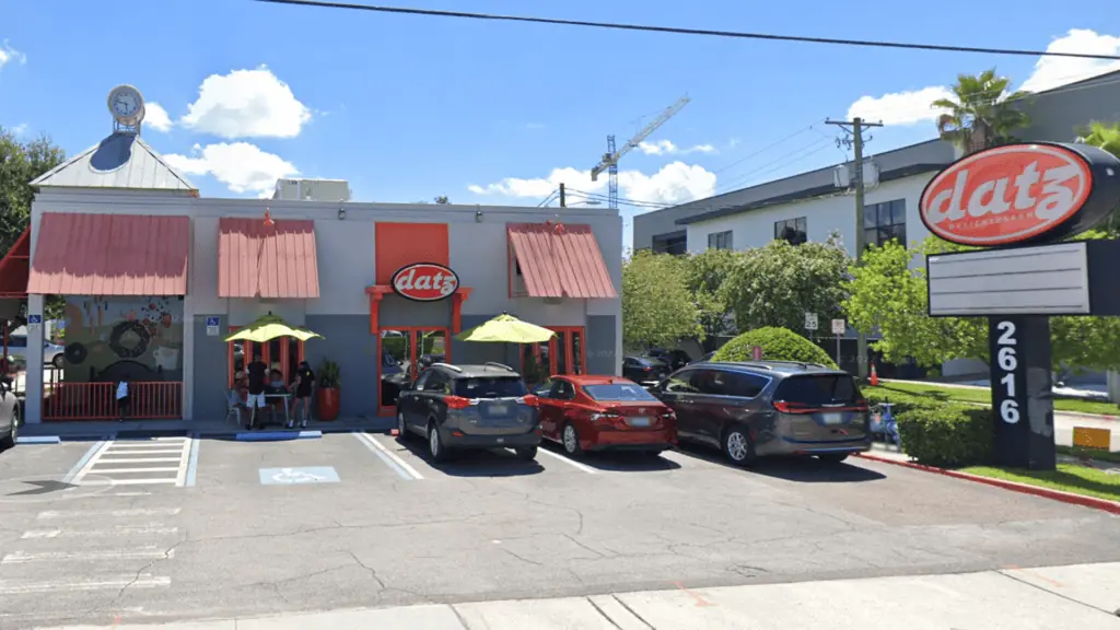 exterior of a restaurant with an orange sign out front.