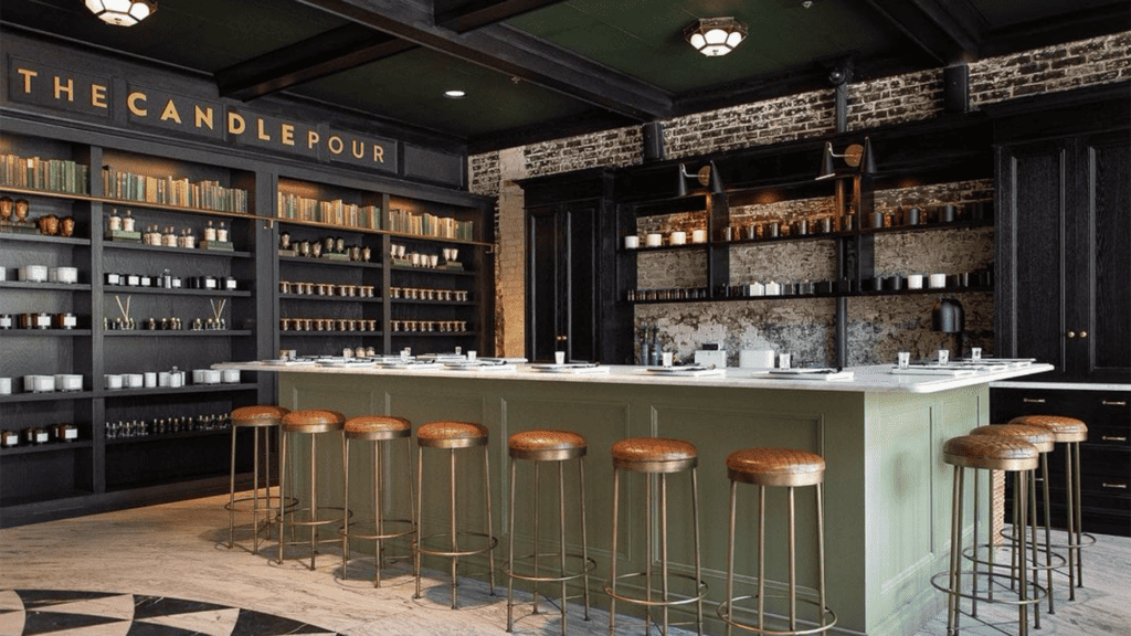 inside a candle pour studio with several bar stools set around a white marble table