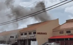 photo of a building with black smoke plumes coming from the roof