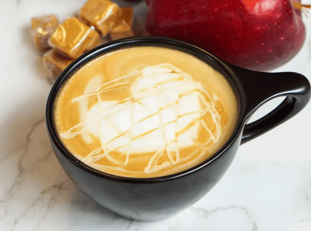 A latte in a black mug with foam set in the shape of a heart. 