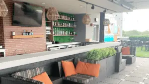 Rooftop bar with orange sofa cushions and green turf