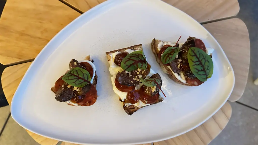 three pieces of crisp bread topped with leaves and figs