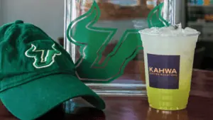 a green coffee drink next to a green baseball hat and a plaque with a green bull logo on the front