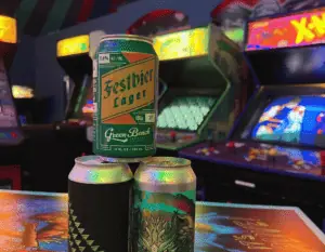 a stack of beer cans in front of old arcade machines