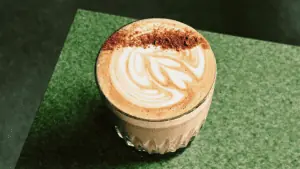 a latte on a table garnished with nutmeg and pumpkin spice