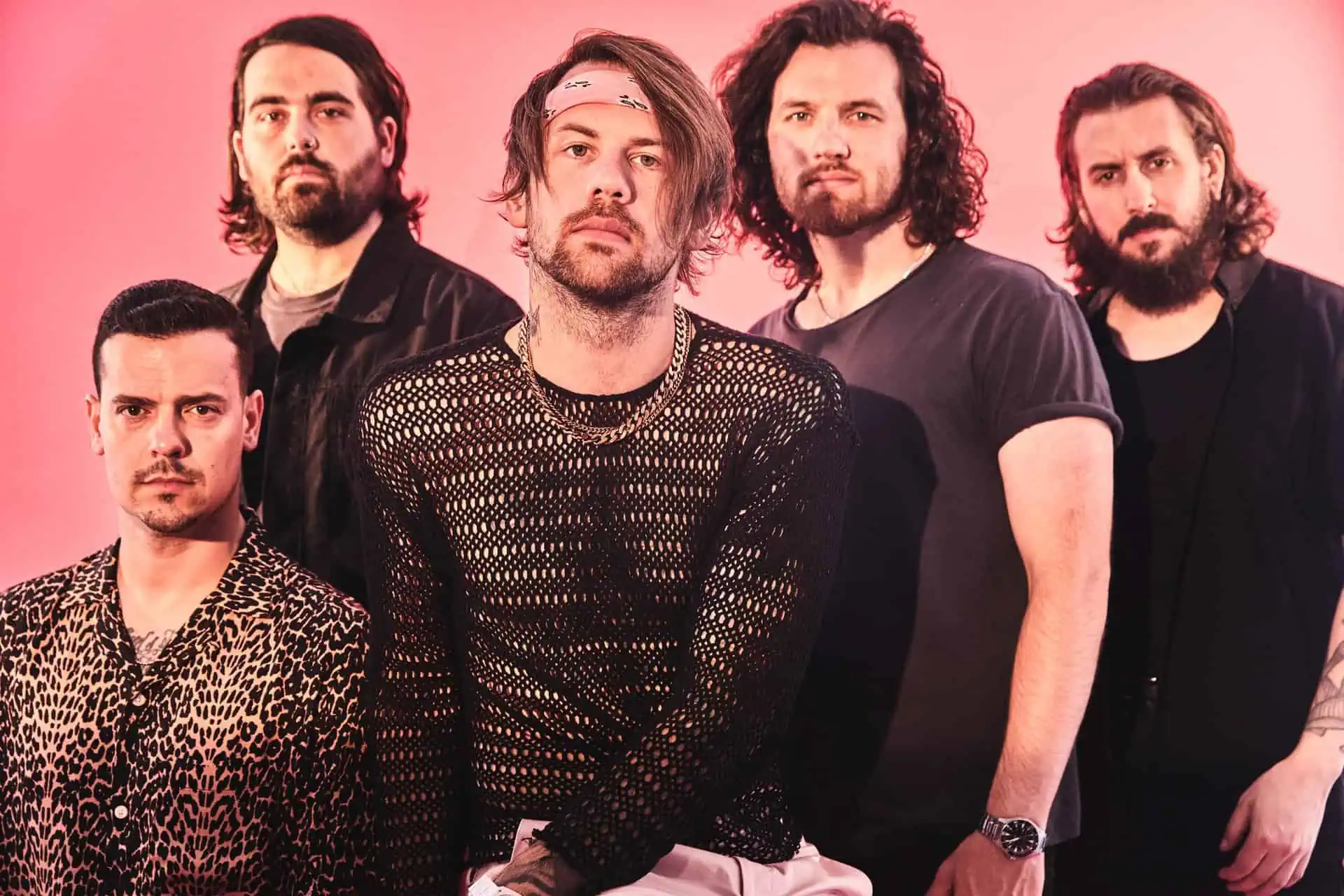 The band beartooth posts on a pink backdrop