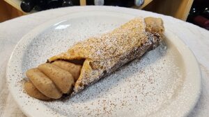 a large cannoli topped with cinnamon sugar