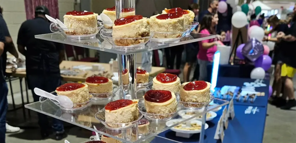 two tiered plates with cheesecake topped with guava sauce