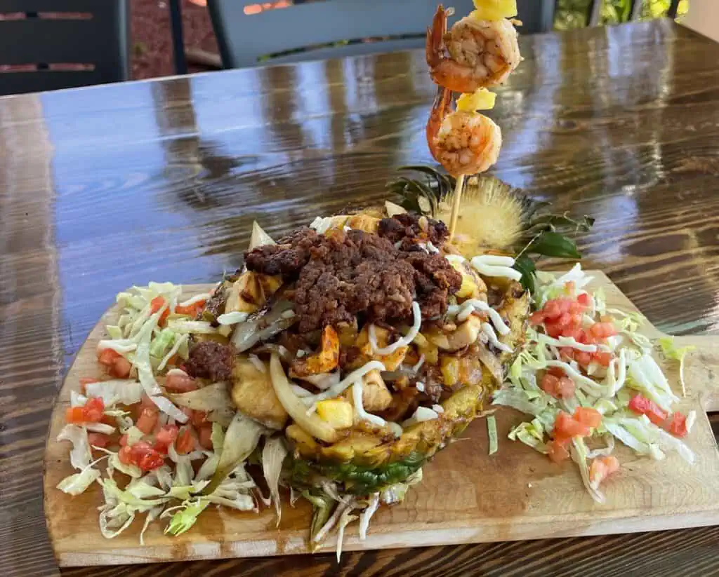 beef and cheese with pineapple chunks in a hollowed out pineapple shell